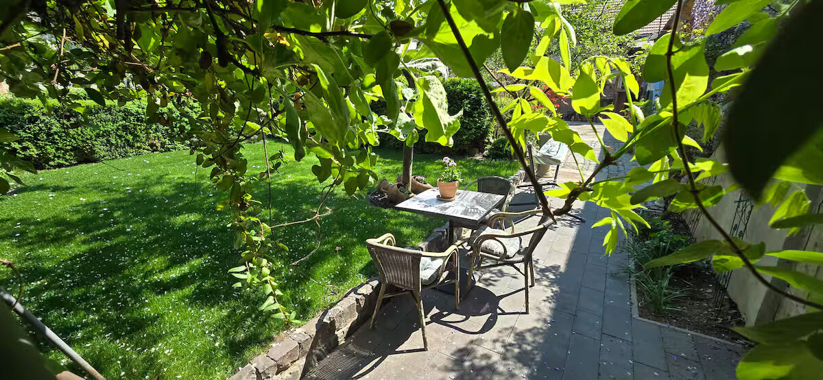 Table and chairs in the garden, under the trees